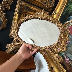 Antique standing mirror with cherubs and ornate detailing